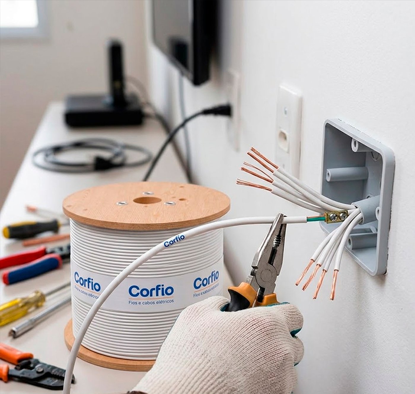 Eletricista instalando Cabo Flexível Corfio Vermelho 4,0 mm² em caixa de passagem de alvenaria