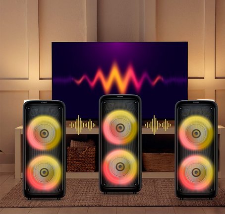 Três Caixas de Som Philips Party Speaker conectadas à TV em sala de estar moderna