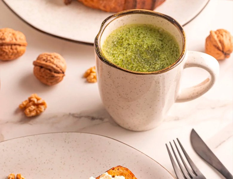 Caneca Oxford Ryo Maresia servida com chá verde matcha acompanhada de torrada com nozes