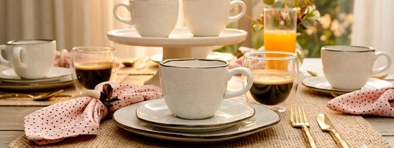 Mesa de café da manhã com xícaras Oxford Ryo Maresia, copos de café, suco de laranja e guardanapo poá