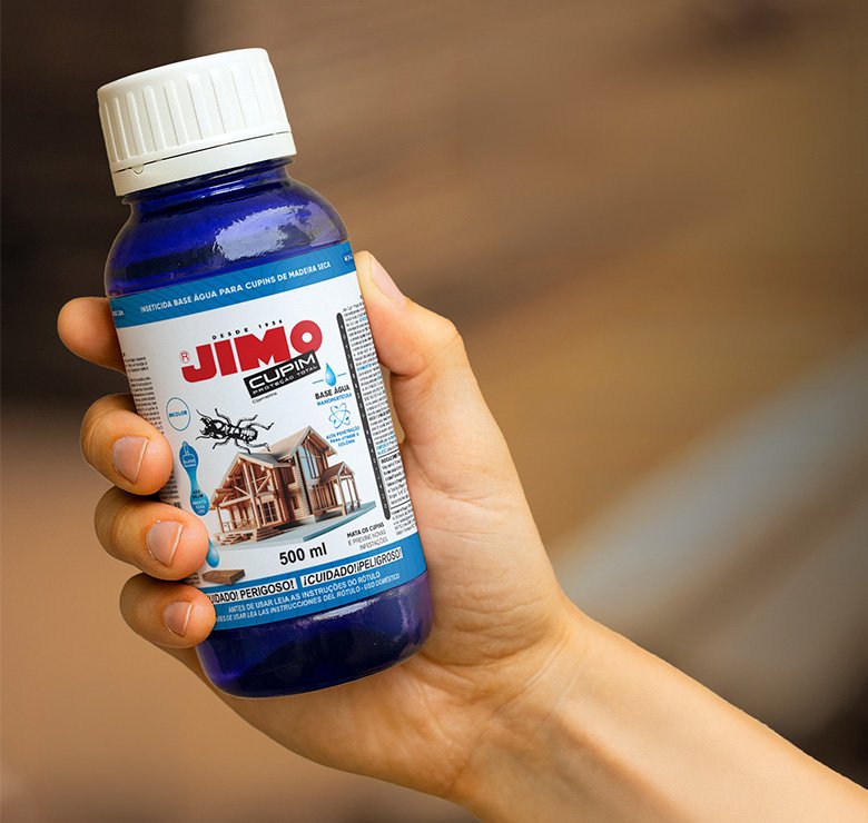 Mão segurando frasco de cupinicida Jimo Cupim Base Água 500ml em ambiente externo