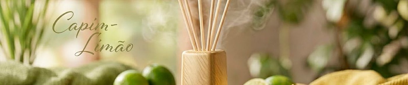 Difusor Aromas Coala Capim-Limão com varetas em destaque e limões ao fundo