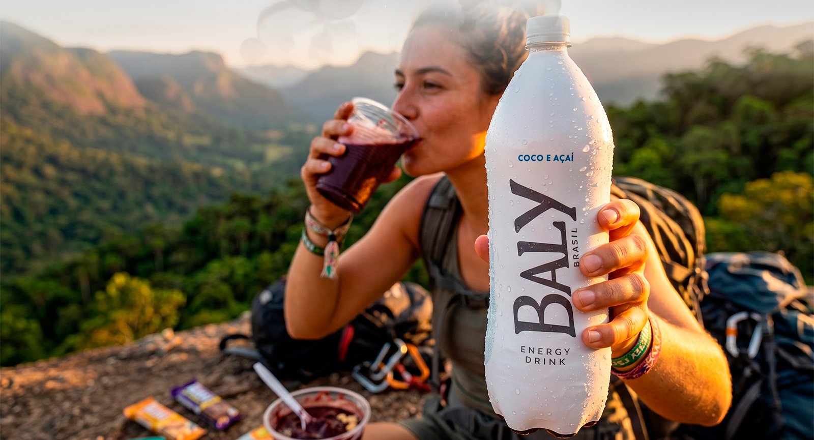 Pessoa bebendo Energético Baly Coco e Açaí 2l em cenário lifestyle