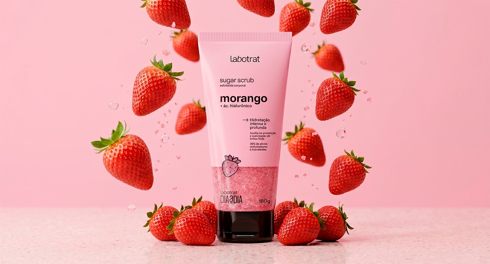 Esfoliante Sugar Scrub Morango Labotrat 180g entre fatias de fruta Morango e fundo rosa