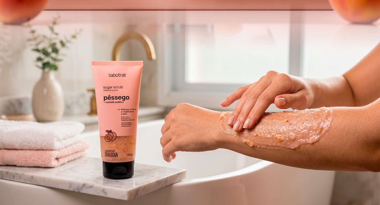 Pessoa aplicando Esfoliante Sugar Scrub Pêssego Labotrat no braço em ambiente de banheiro