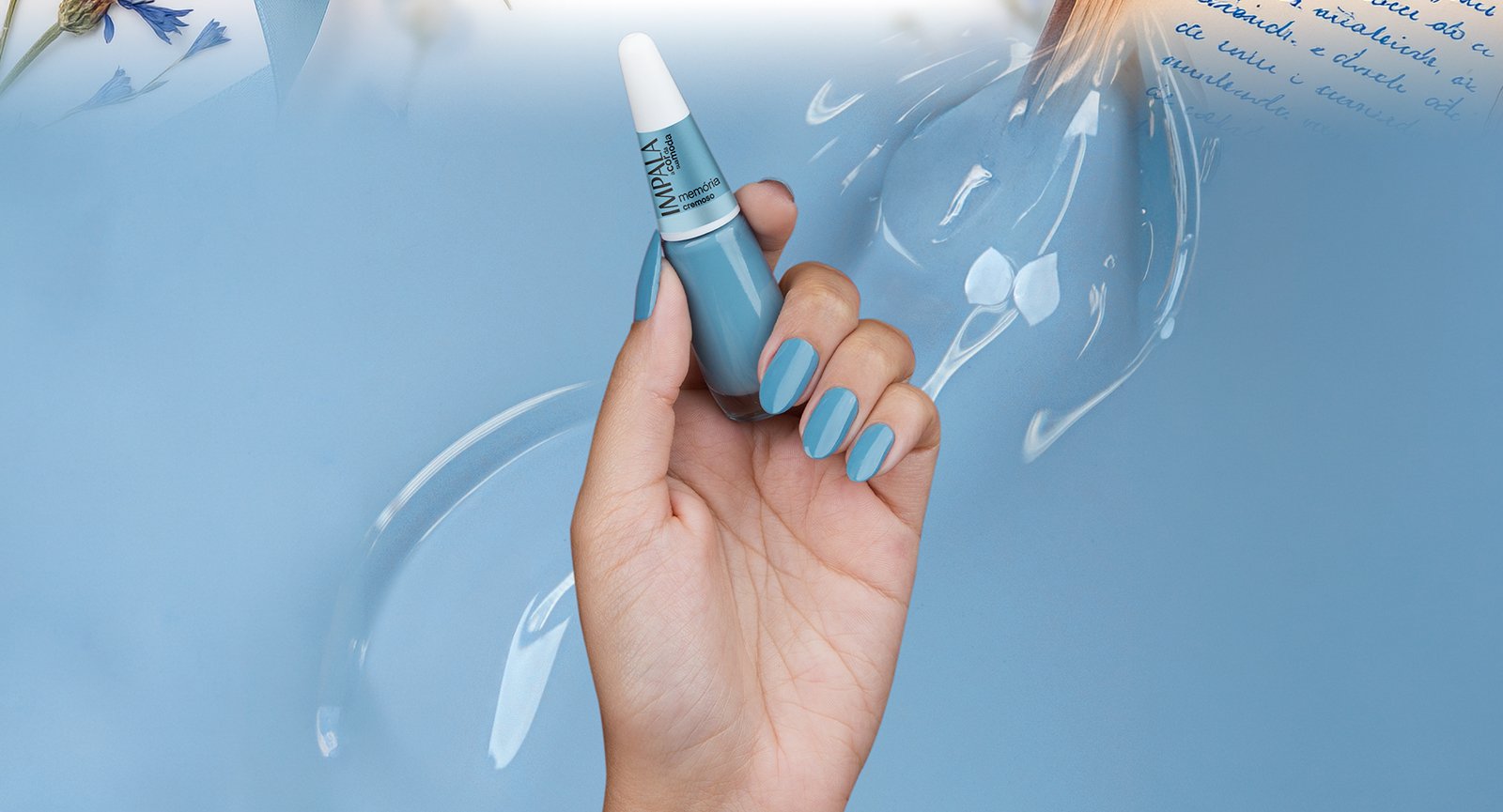 Mão segurando Esmalte Impala Memória cremoso aplicado em unhas longas com fundo azul