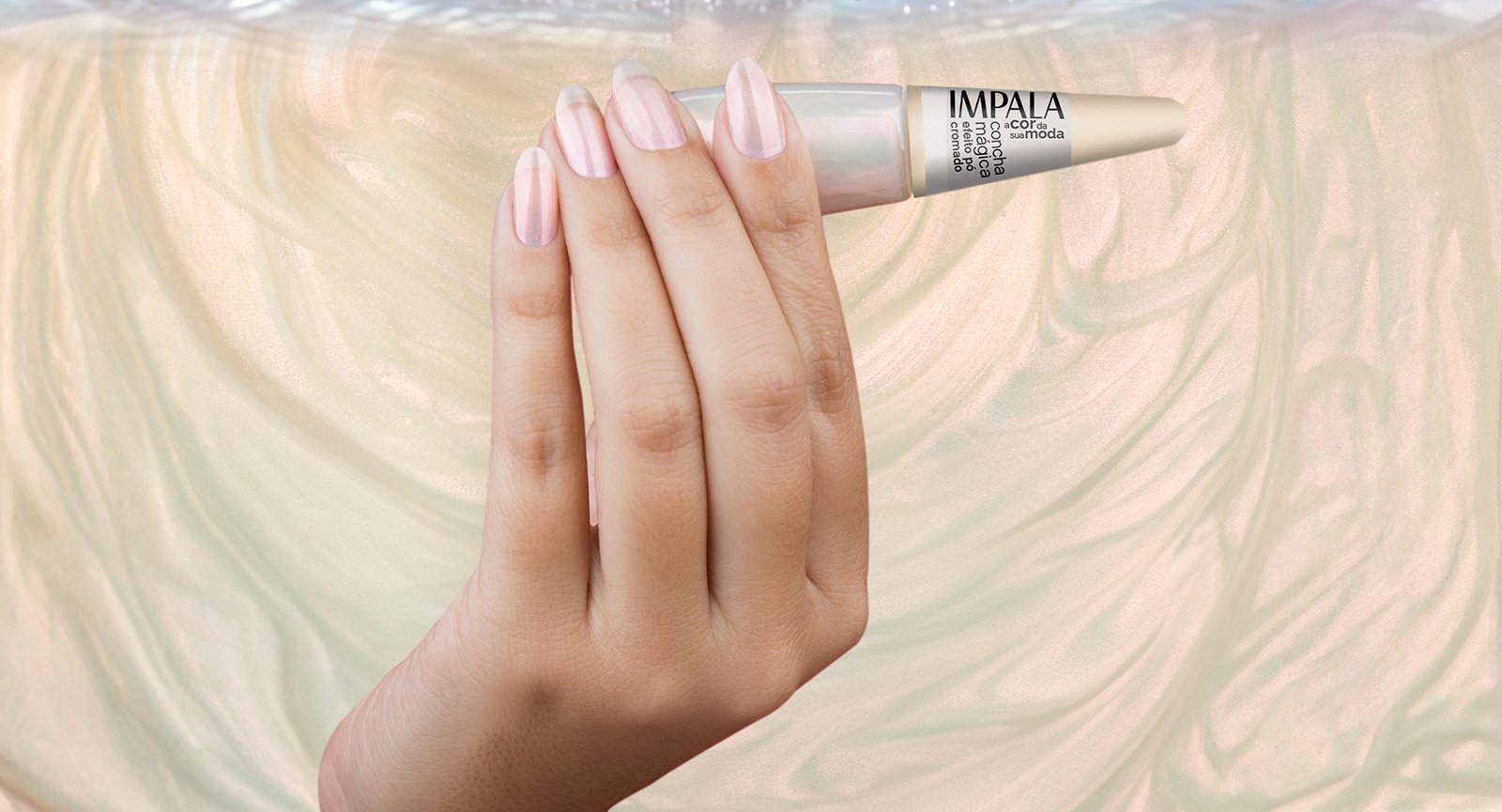 Mão segurando Esmalte Impala Concha Mágica efeito pó cromado — unhas longas pintadas em tom perolado rosado