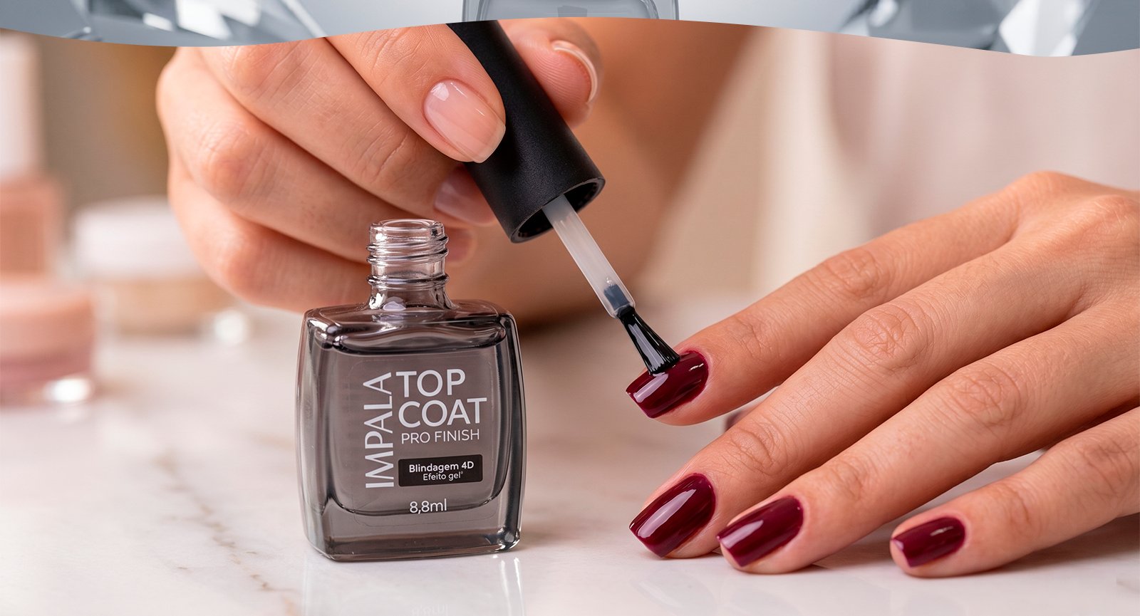 Mulher aplicando Esmalte Impala Top Coat Pro Finish Blindagem 4D sobre unhas pintadas de vermelho escuro