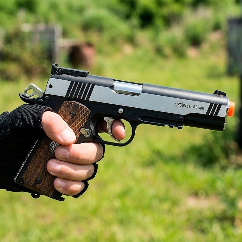 Pistola de pressão em composição escura com foco nos detalhes