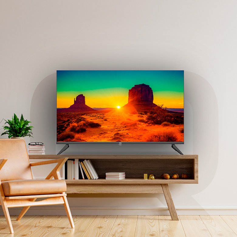 Smart TV HQ 43 polegadas instalada em móvel de madeira na sala de estar exibindo pôr do sol