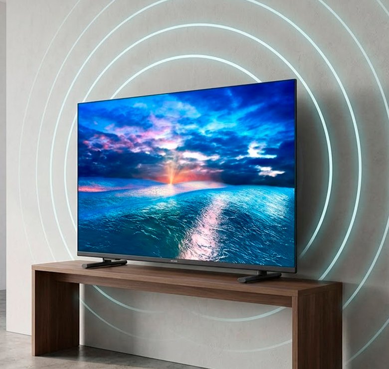 Smart TV Philips em rack de madeira com ondas sonoras ilustrativas destacando som Dolby Audio