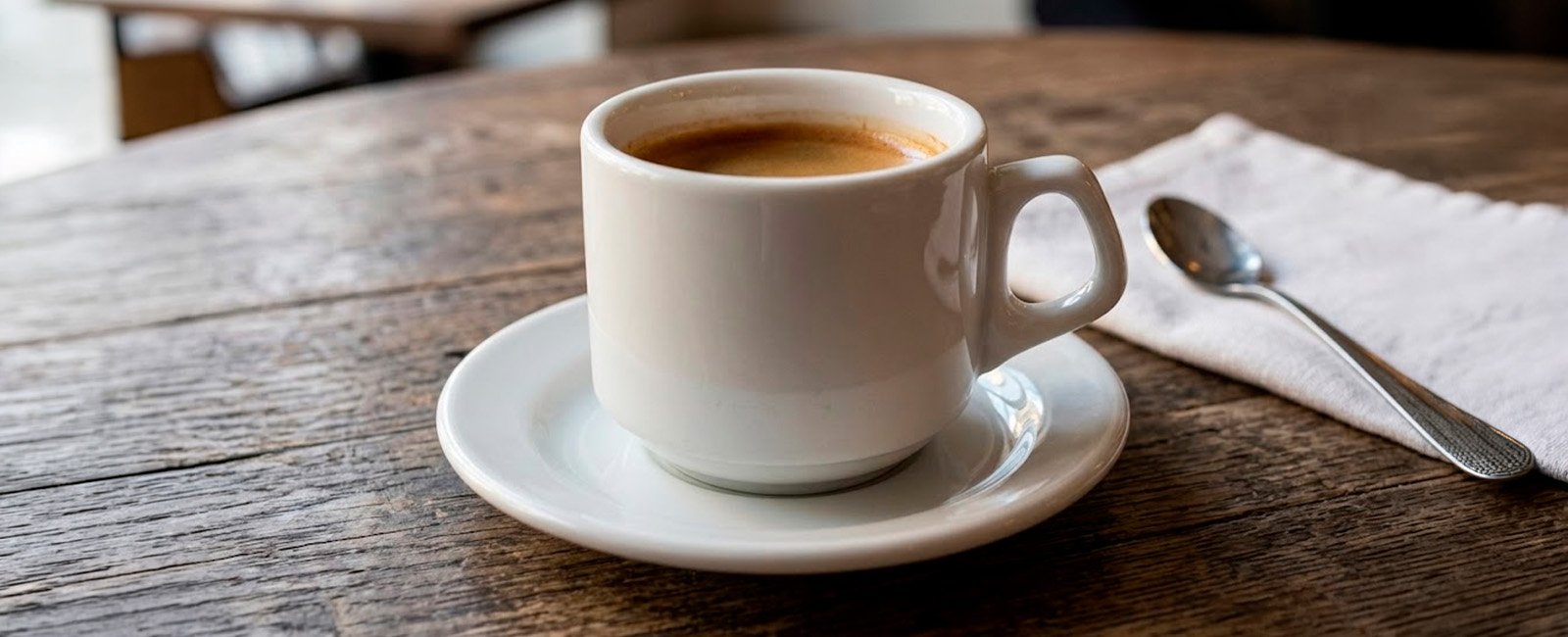 Xícara de chá Biona Vitramik com café servido e pires sobre mesa de madeira rústica